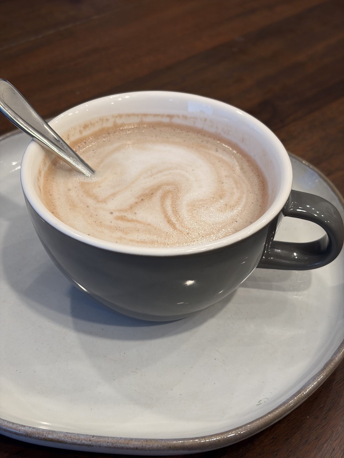A cup of drinking chocolate topped with steamed milk foam